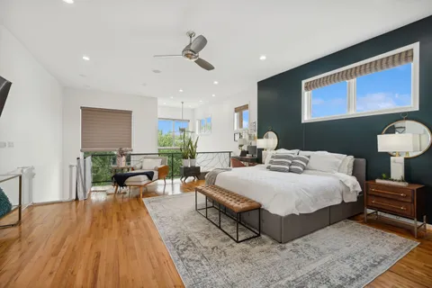 a spacious bedroom with a bed a couch and wooden floor