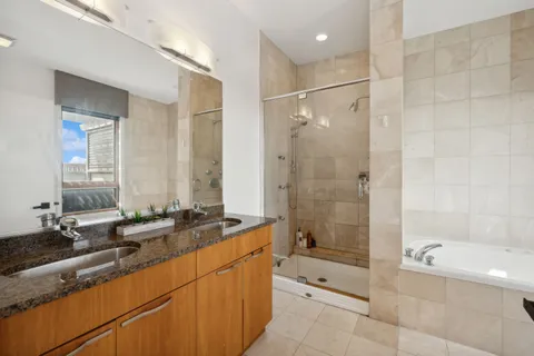 a bathroom with a granite countertop sink a toilet a mirror and shower