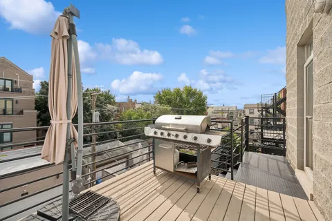 a view of a balcony with wooden floor and barbeque oven