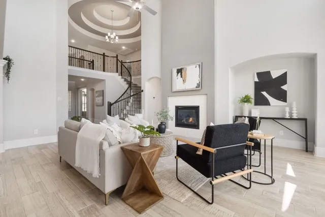 a living room with furniture a fireplace and a chandelier