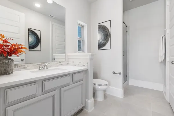 a bathroom with a toilet sink double vanity and mirror