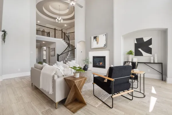a living room with furniture a fireplace and a chandelier