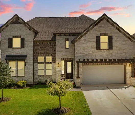 a front view of a house with a garden and yard