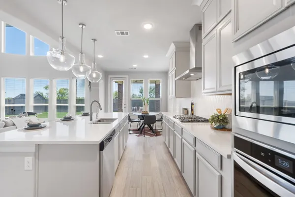 an open kitchen with stainless steel appliances granite countertop a lot of counter space and wooden floors