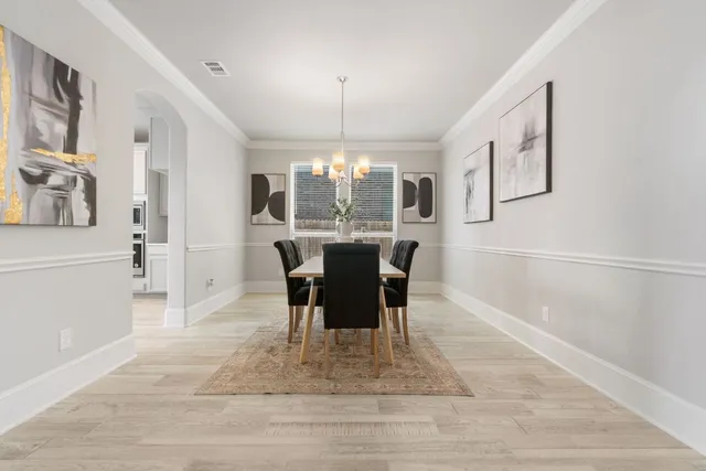 a dining room with furniture a chandelier and wooden floor