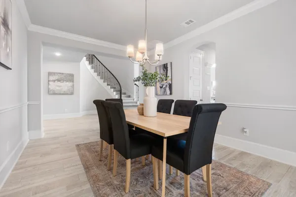 a view of a dining room with furniture and a chandelier