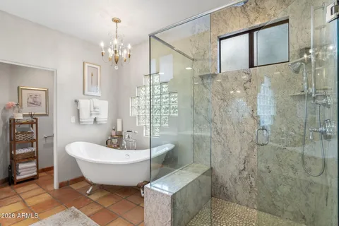 a spacious bathroom with a double vanity sink a toilet a glass door shower and a mirror