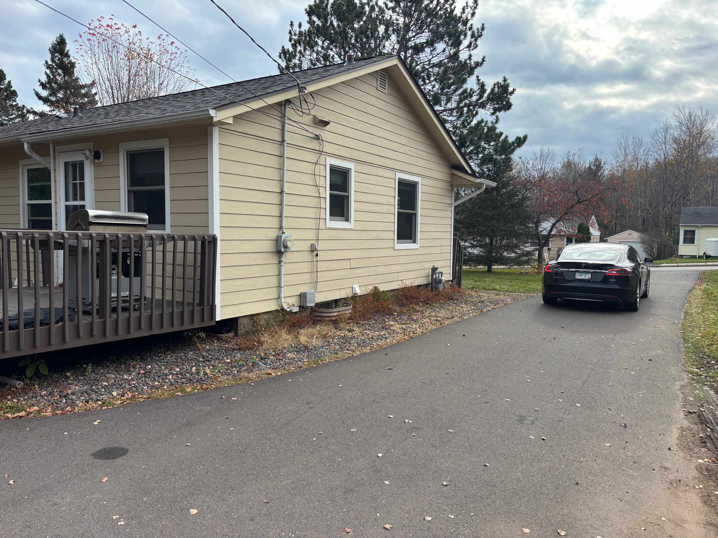 937 West Arrowhead Road Duluth, MN 55811 - Photo 16 of 23 View of side of property with a wooden deck, roof with shingles, and driveway.