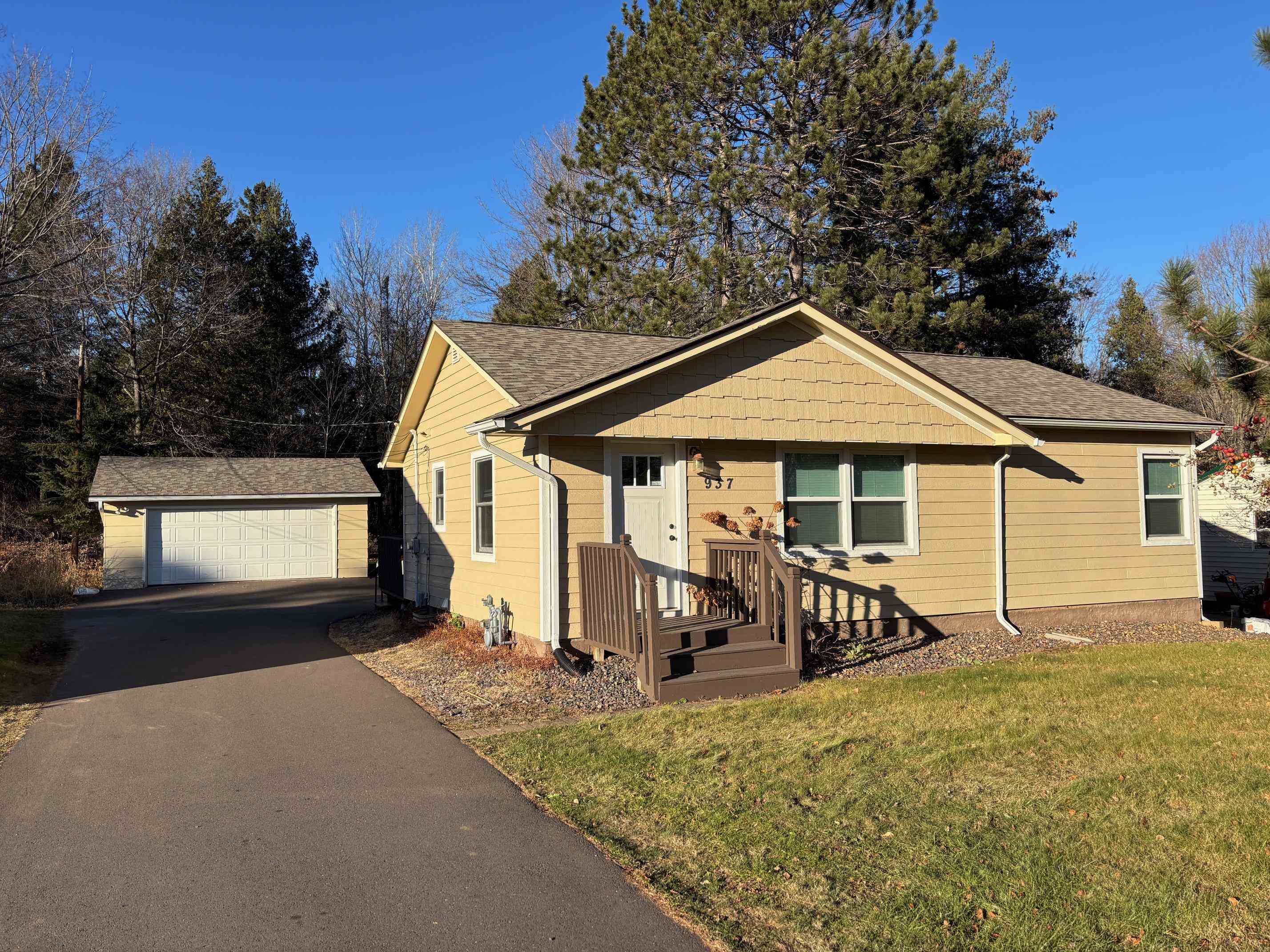 937 West Arrowhead Road Duluth, MN 55811 - Photo 18 of 23 View of front of house featuring an outbuilding, a deck, a front lawn, a garage, and a shingled roof
