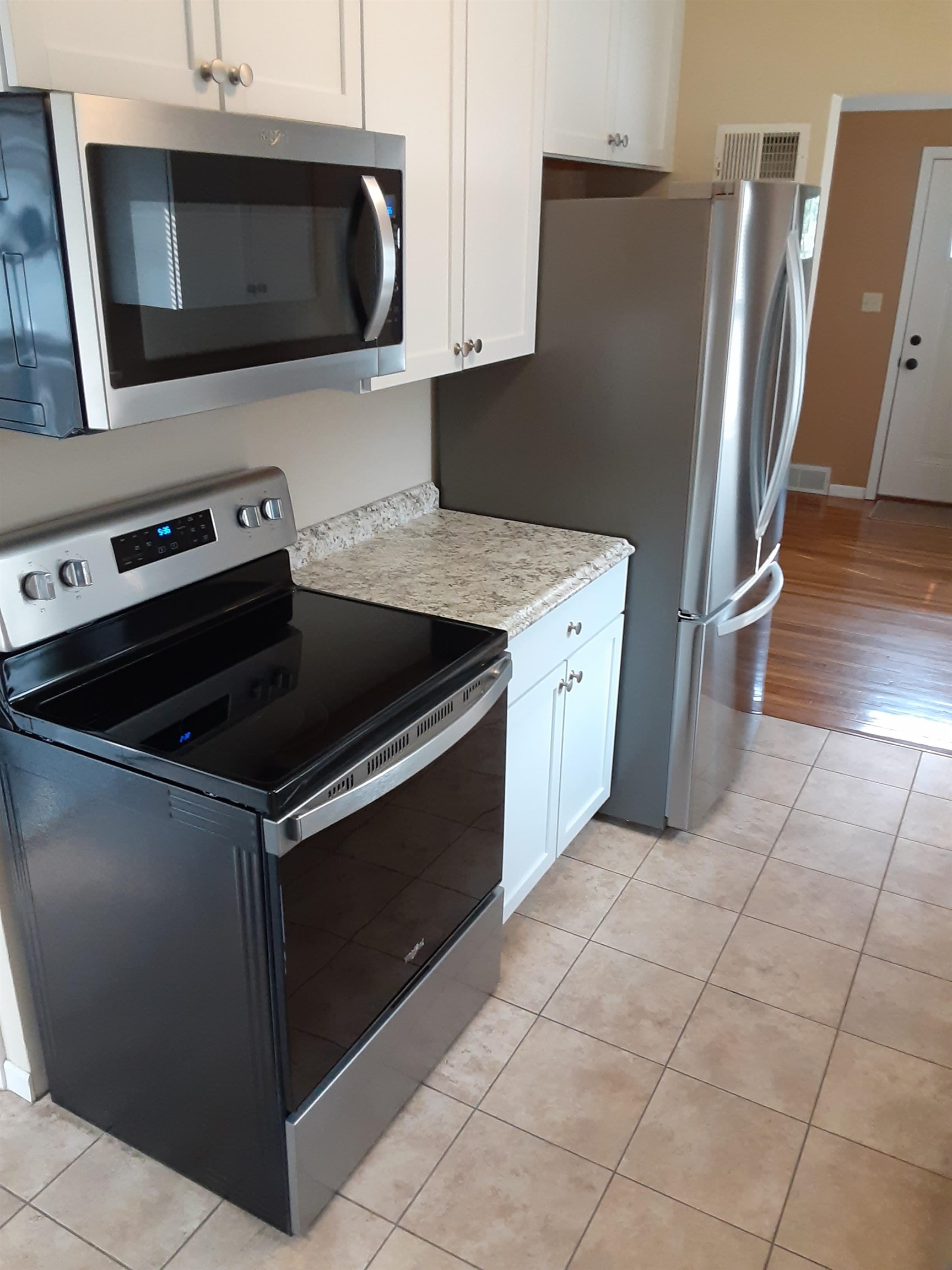 937 West Arrowhead Road Duluth, MN 55811 - Photo 8 of 23 Kitchen featuring appliances with stainless steel finishes, light tile patterned floors, and white cabinets.