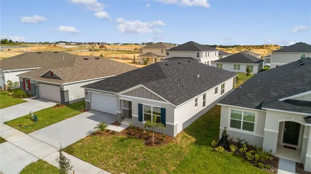 an aerial view of a house with a garden and lake view