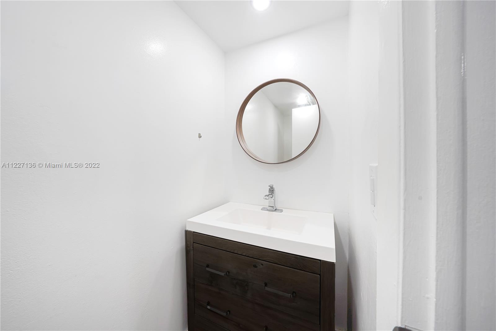 3670 Inverrary Drive, Unit 1I Lauderhill, FL 33319 - Photo 13 of 14 a bathroom with a sink and a mirror