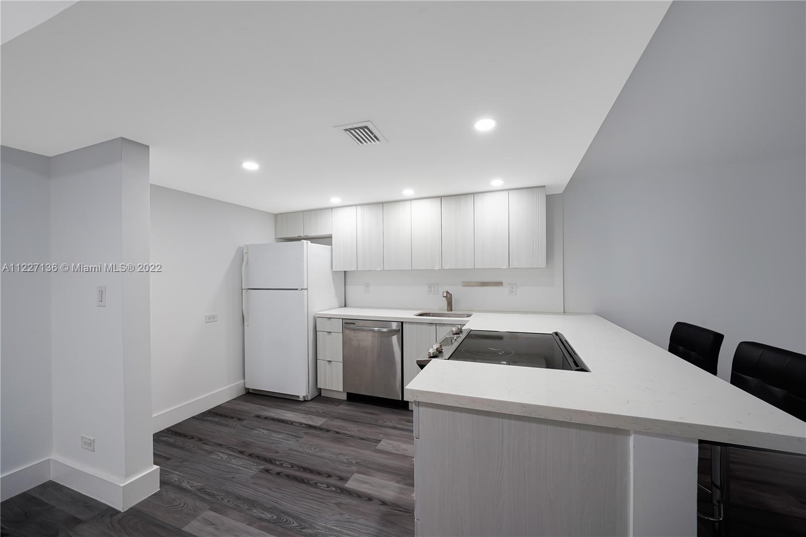 3670 Inverrary Drive, Unit 1I Lauderhill, FL 33319 - Photo 3 of 14 a kitchen that has a sink a refrigerator and cabinets