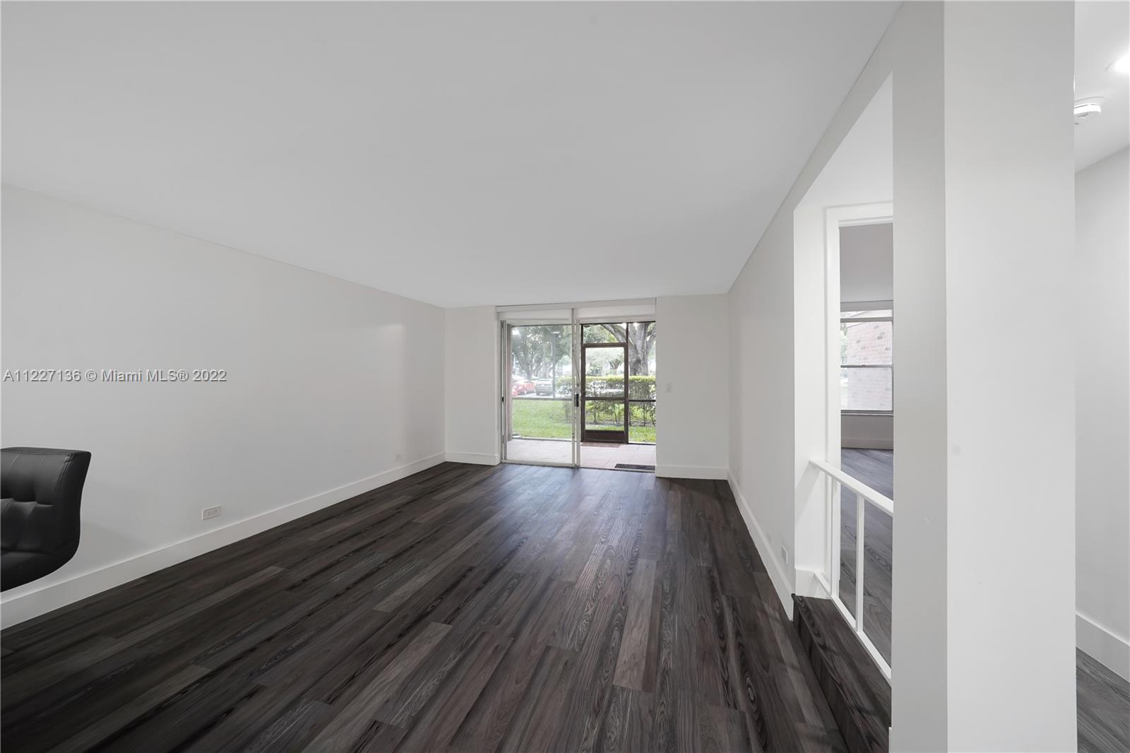3670 Inverrary Drive, Unit 1I Lauderhill, FL 33319 - Photo 5 of 14 a view of an empty room with wooden floor and a window
