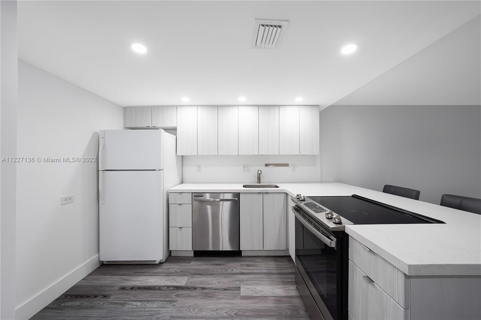 3670 Inverrary Drive, Unit 1I Lauderhill, FL 33319 - Photo 7 of 14 a kitchen with a stove a refrigerator and a sink