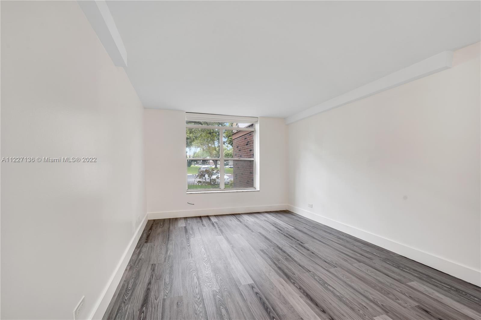 3670 Inverrary Drive, Unit 1I Lauderhill, FL 33319 - Photo 10 of 14 an empty room with wooden floor and windows