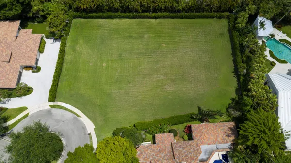 an aerial view of a house with a yard lake and outdoor seating