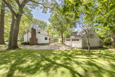 a backyard of a house with table and chairs
