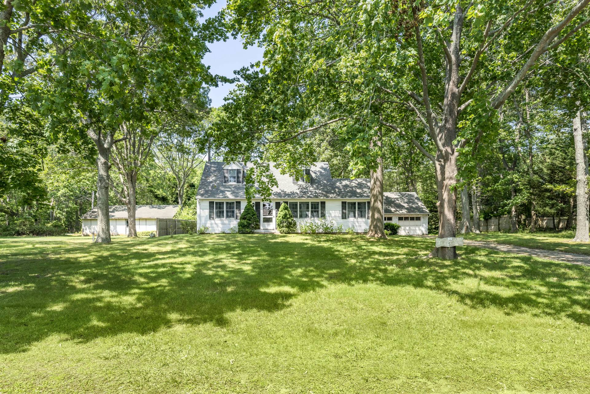 95 Sayre's Path Wainscott, NY 11975 - Photo 5 of 14 a front view of a house with a garden