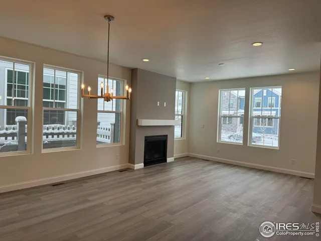 a view of an empty room with window and fire place