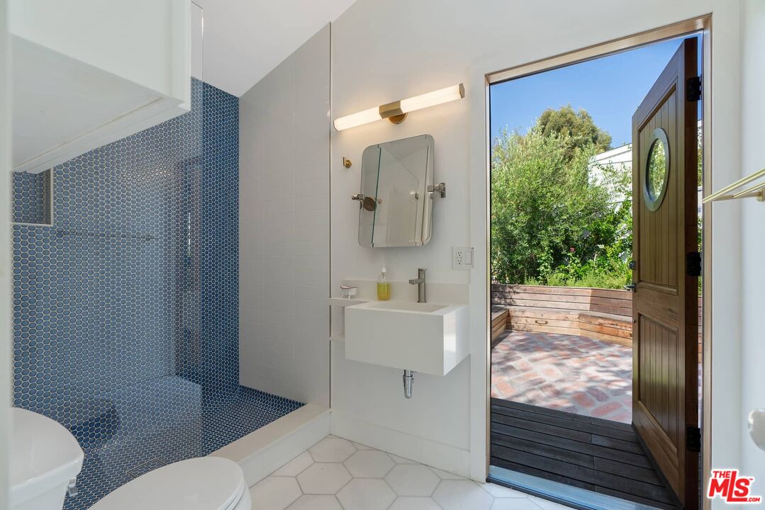 249 Paradise Cove Road Malibu, CA 90265 - Photo 27 of 41 a bathroom with a toilet a sink a shower and mirror