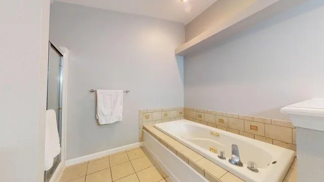 a bathroom with a tub a sink and mirror