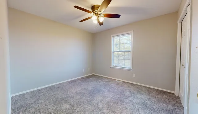 a view of a livingroom with a ceiling fan and window