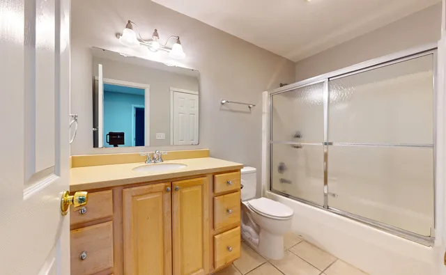 a bathroom with a granite countertop sink toilet a mirror and shower