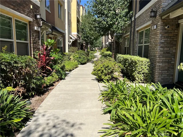 a view of a pathway with flower garden