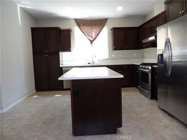 a kitchen with a sink a refrigerator and cabinets