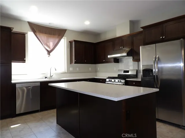 a kitchen with stainless steel appliances a sink stove and refrigerator