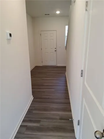 a view of a hallway with wooden floor and staircase