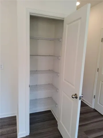 a view of walk in closet with wooden floor