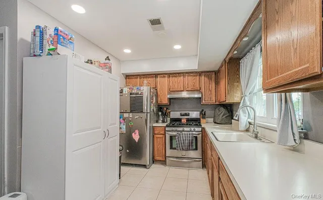 a kitchen with stainless steel appliances granite countertop a refrigerator sink and stove