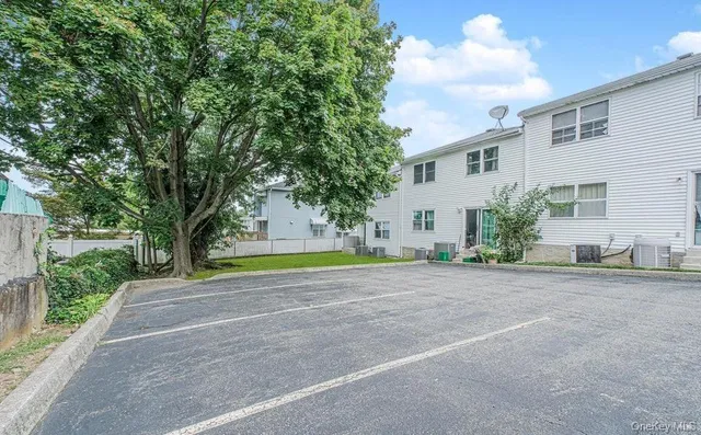 a view of a house with a backyard and a tree