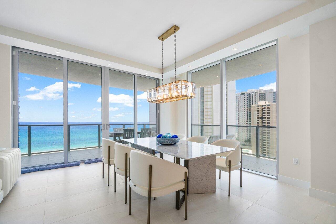 3100 North Ocean Drive, Unit 1505 Riviera Beach, FL 33404 - Photo 11 of 60 a dining room with furniture window chairs and chandelier