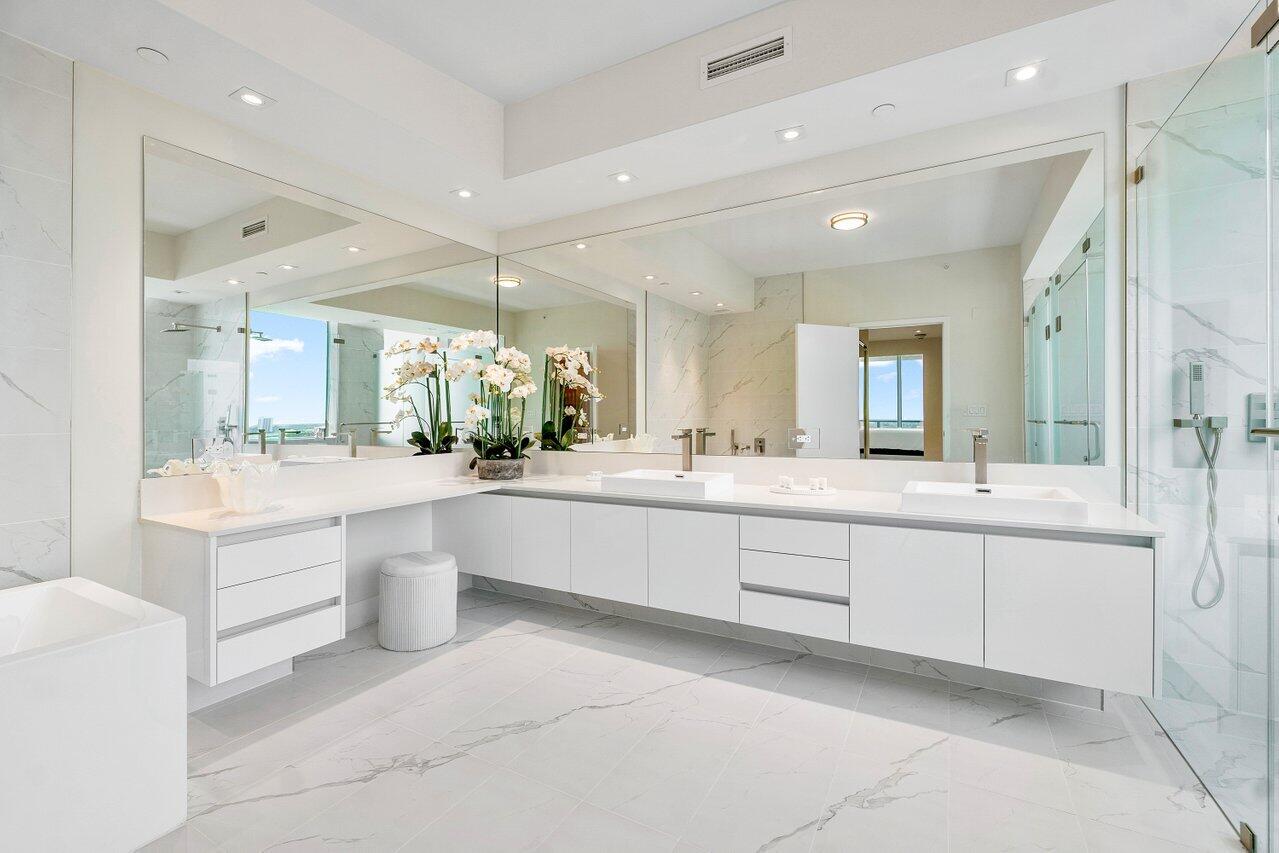 3100 North Ocean Drive, Unit 1505 Riviera Beach, FL 33404 - Photo 23 of 60 a large white bathroom with a large tub vanity sink and mirror