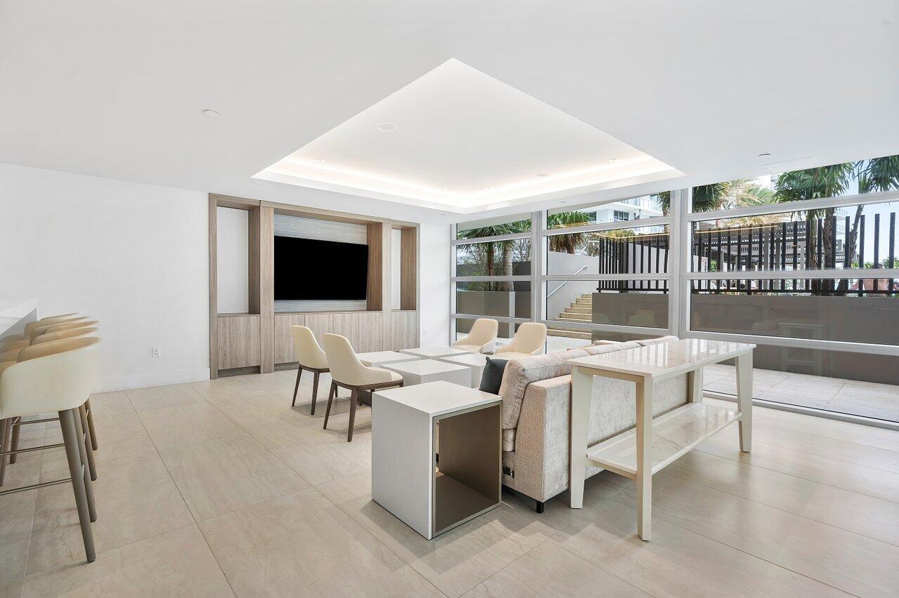 3100 North Ocean Drive, Unit 1505 Riviera Beach, FL 33404 - Photo 45 of 60 a living room with furniture a flat screen tv and floor to ceiling window