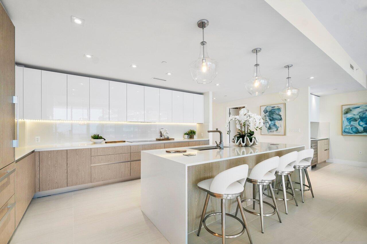 3100 North Ocean Drive, Unit 1505 Riviera Beach, FL 33404 - Photo 9 of 60 a kitchen with stainless steel appliances granite countertop a table and chairs in it