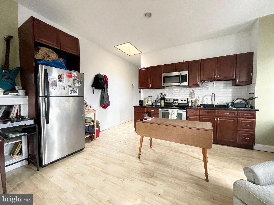 4631 Locust Street Philadelphia, PA 19139 - Photo 2 of 7 a kitchen with stainless steel appliances kitchen island granite countertop a refrigerator and a stove top oven