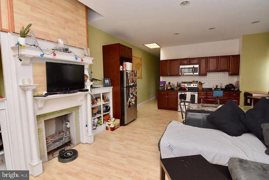 4631 Locust Street Philadelphia, PA 19139 - Photo 3 of 7 a living room with furniture a flat screen tv and a fireplace