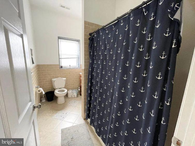 4631 Locust Street Philadelphia, PA 19139 - Photo 5 of 7 a bathroom with a toilet and a shower curtain