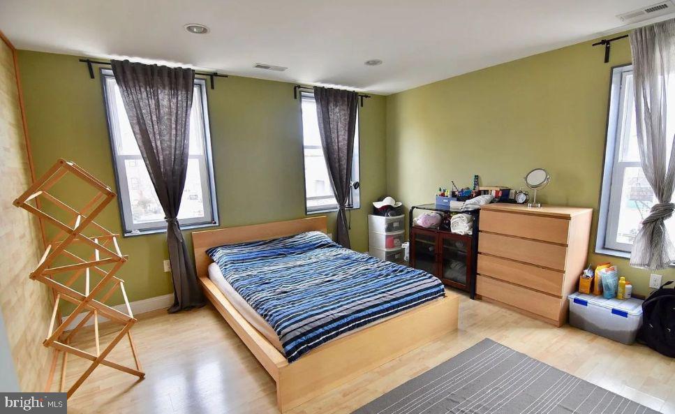 4631 Locust Street Philadelphia, PA 19139 - Photo 6 of 7 a bedroom with a bed and wooden floor