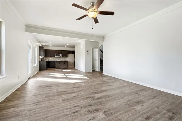 a view of empty room with wooden floor and ceiling fan