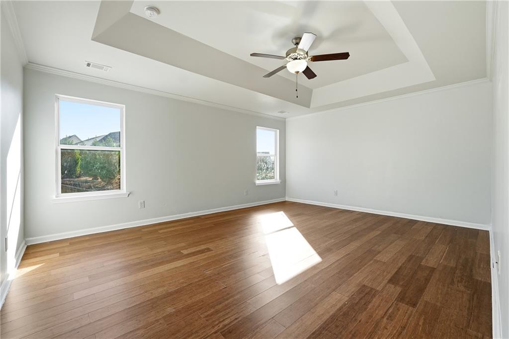677 Massey Street Winder, GA 30680 - Photo 19 of 30 an empty room with wooden floor chandelier fan and windows