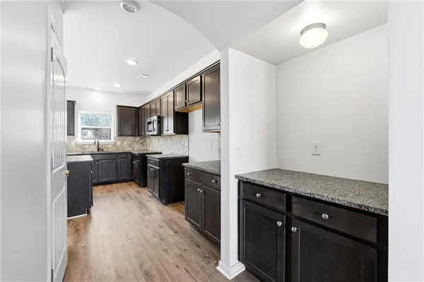a kitchen with a sink a refrigerator and cabinets