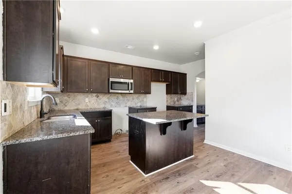 a kitchen with stainless steel appliances granite countertop a sink and a stove