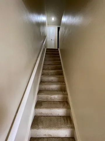 a front view of a house with a garden and trees