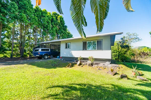 a view of a house with backyard sitting area and garden