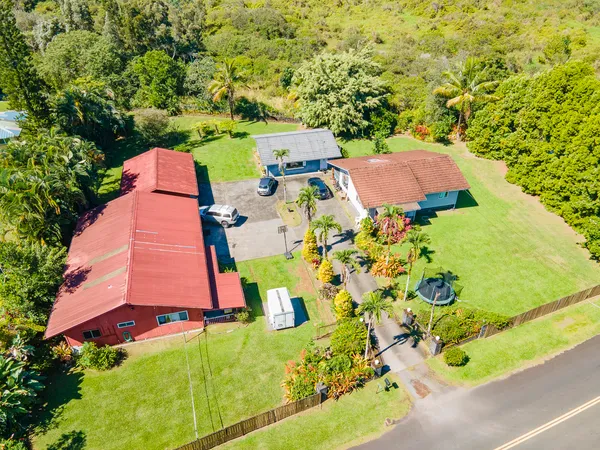an aerial view of a house with a yard and swimming pool